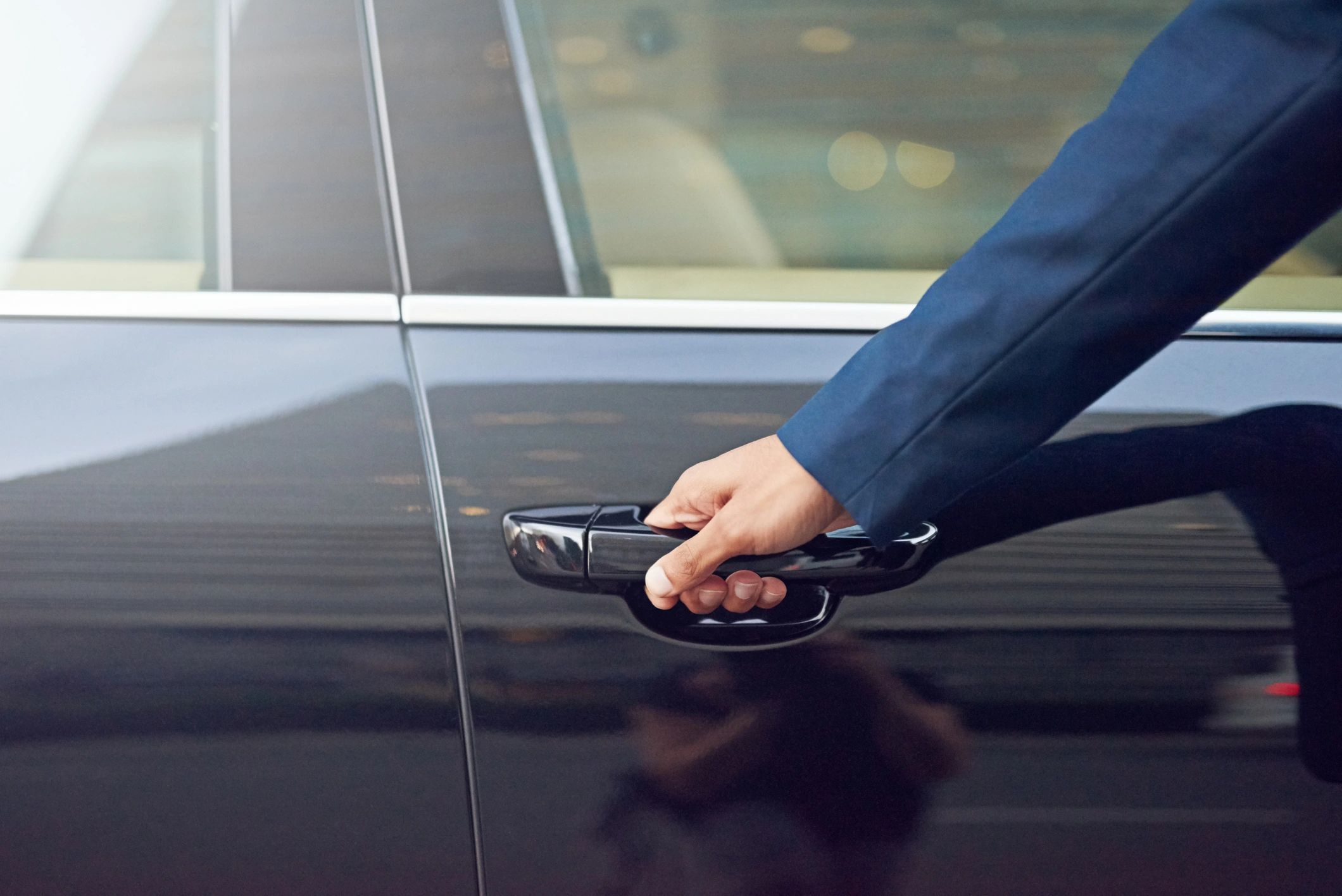 Professional chauffeur opening a car door